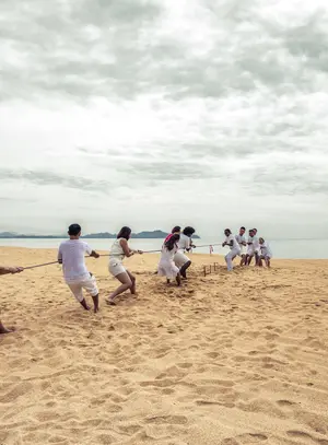 Team playing tug of war on the beach